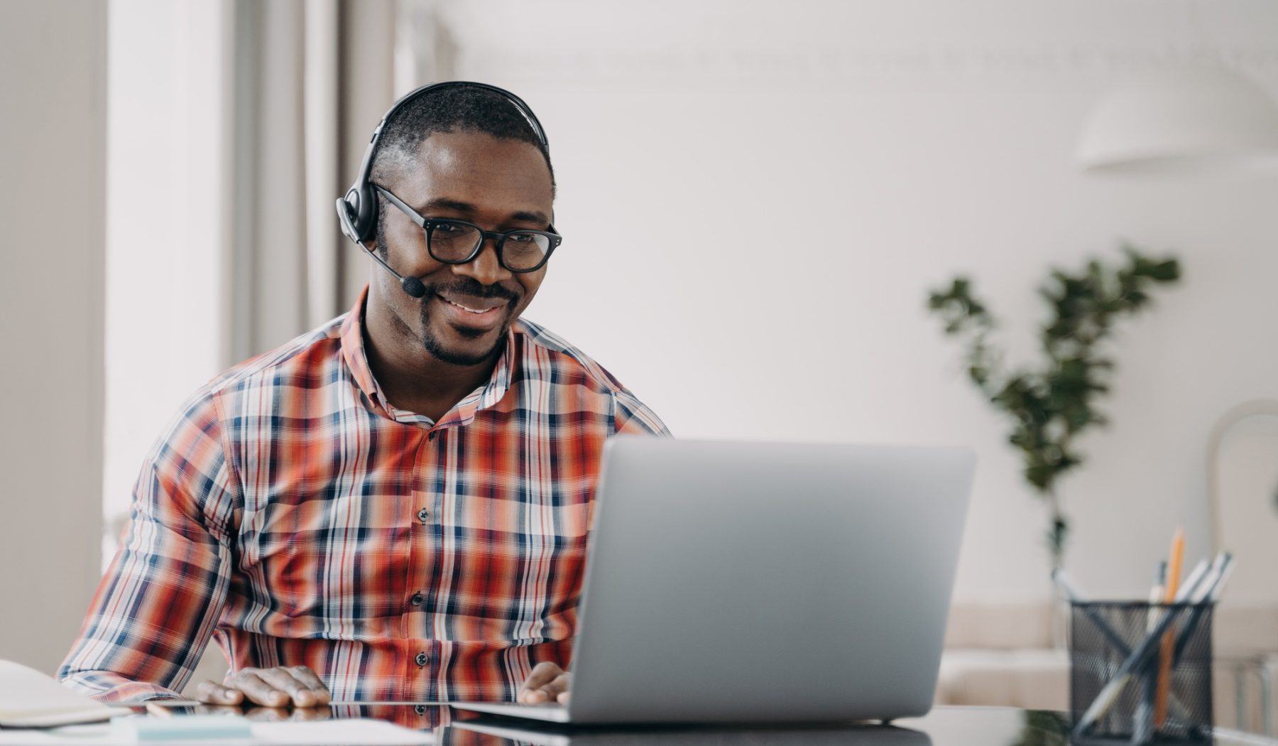 African american male student wearing headset learn language online at laptop. Distance education